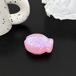 Close-up of pink fish-shaped phone grip with embossed Fu character and glitter finish