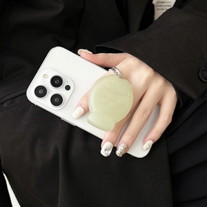 Close-up of light green fish-shaped phone grip holder on smartphone with translucent texture