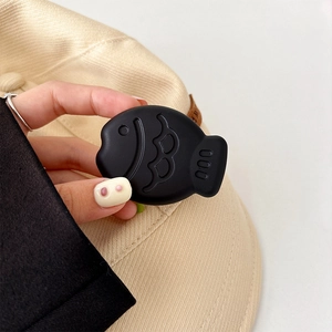 Close-up of black fish-shaped foldable phone grip made of soft silicone material