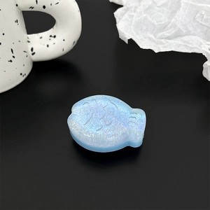 Macro detail of a 3D blue glitter fish-shaped resin grip with pearlescent finish