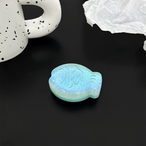 Detail of creative fish shaped phone stand with blue glitter resin and iridescent finish