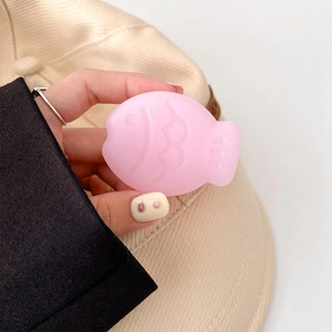 Close-up of a pink fish-shaped massage tool being held for facial and body Gua Sha skincare