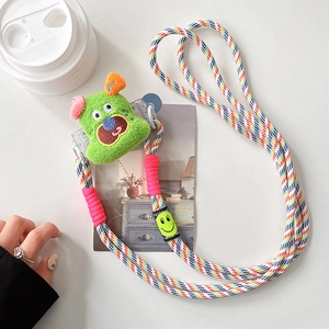 Détail d'une bandoulière de téléphone tissée colorée avec décor de monstre en peluche