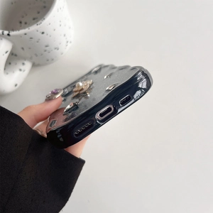 Détails du port de charge d'une coque iPhone avec fleurs de camélia et strass