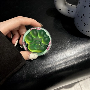 Detail of a gradient green cat paw phone grip featuring translucent resin and heart relief
