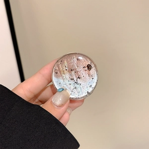 Macro detail of round phone socket with gradient glitter and silver foil inlay