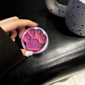 Detailed macro view of a 3D cat paw phone grip with heart embossing and Good Luck text