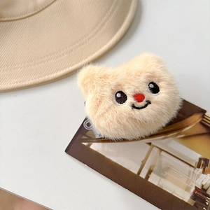 Detail of cute beige plush bear charm with fine embroidery and soft furry texture
