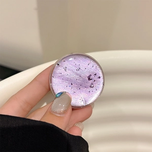 Macro shot of a purple glitter resin phone grip showing starry foil textures and shine