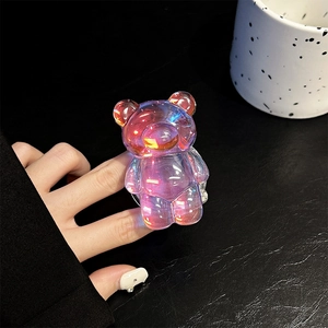 Detailed macro view of iridescent laser bear phone grip holder on textured leather surface