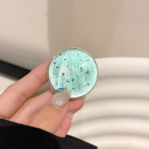 Close-up of a mint green glitter phone grip with resin texture and sparkling sequins