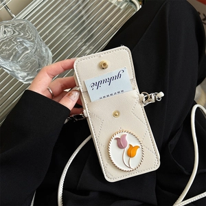Detail of white quilted crossbody phone case with a floral tulip charm and card slots