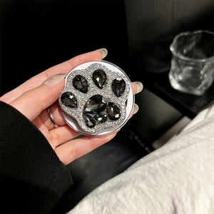 Detailed view of the sparkling rhinestone cat paw magnetic phone socket held in hand