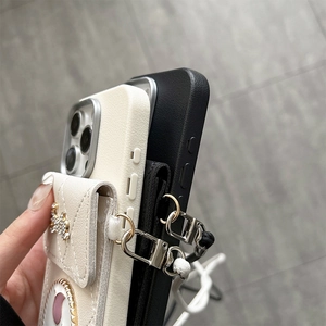 Detail of crossbody tulip wallet phone case with quilted card holder and bow charm