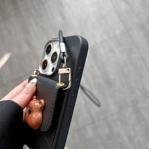 Detail of black leather texture phone case with 3D bear card holder and crossbody strap
