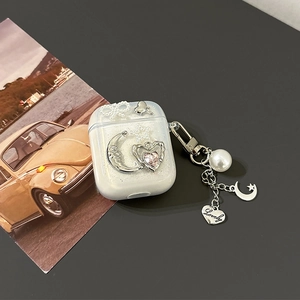 Detailed view of pearlescent AirPods Pro 2 case with moon, heart, and pearl charms