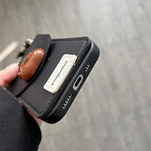 Detail of iPhone case with black leather texture and brown 3D bear card holder design