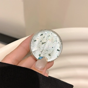 Detailed macro view of a luxury phone grip with silver glitter and blue teardrop gem
