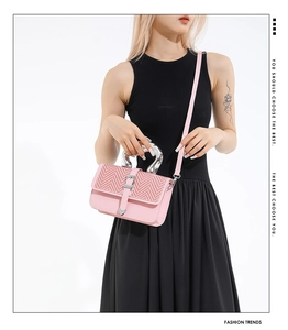 Close-up of pink crossbody bag with V-shaped knit texture and horseshoe metal handle