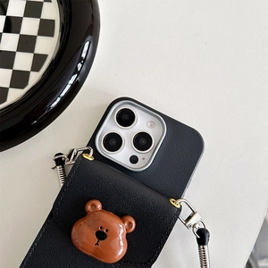 Detail of black lychee leather phone case with 3D brown bear and crossbody strap