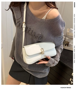 Détail du sac rectangulaire blanc avec fermoir doré et bandoulière en cuir souple