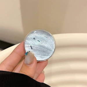 Detail of silver foil phone grip with blue sequins under a clear protective dome