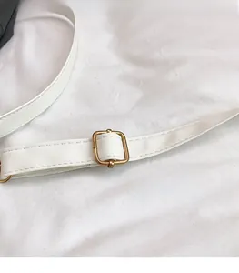 Nahaufnahme des weißen Leder-Schultergurts mit verstellbarer goldener Metallschnalle und feinen Nähten
