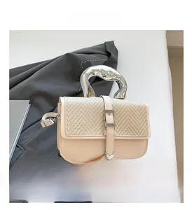 Detail of woven cream flap bag with unique silver organic-shaped metal top handle