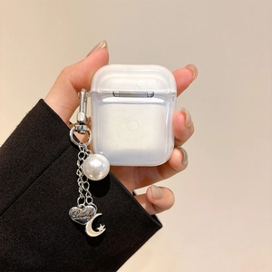 Detail of transparent AirPods case featuring a pearl, heart, and star moon keychain