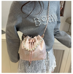 Detailansicht der rosa Jacquard-Beuteltasche mit Blumenstickerei und Perlenkette