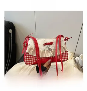 Detail of red gingham patchwork bag with ruffle trim and heart bow pendant
