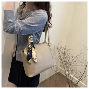 Detail of apricot textured PU leather tote bag with elegant silk scarf and slim shoulder straps