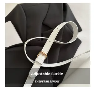 Gros plan de la bandoulière en similicuir blanc avec boucle en métal doré réglable