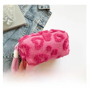 Detalle de neceser de peluche con corazones 3D y asa suave de piel sintética