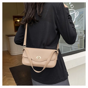Nahaufnahme der beigen Leder-Baguette-Tasche mit goldener ovaler Drehschnalle