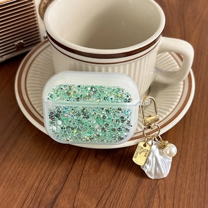 Detail of AirPods Pro case with green glitter, shell pendant, and pearl charm