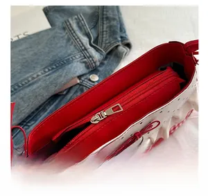 Detailed top view of the smooth metal zipper and red interior of the polka dot handbag