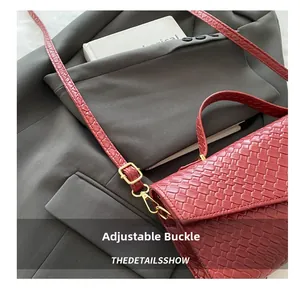 Dettaglio della borsa a tracolla rossa intrecciata con fibbia dorata regolabile