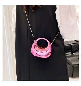 Close-up of pink mirror acrylic bag with round handle and gold chain strap detail
