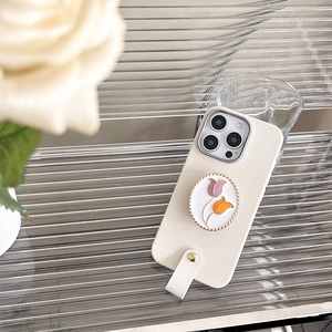 Detail der cremefarbenen iPhone-Hülle mit Tulpen-Halter und Band auf Glas-Hintergrund