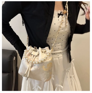 Nahaufnahme der Vintage-Stickerei und des eleganten Perlengriffs an der Eimertasche