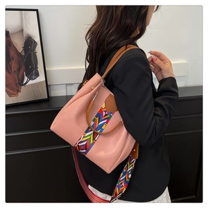 Pink shoulder bag detail showing woven bohemian straps and leather texture handles