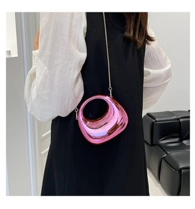 Irregular pebble-shaped acrylic evening bag with a circular handle and gold chain strap