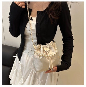 Detail of floral embroidery and pearl handle on a satin drawstring bucket bag