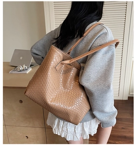 Detailed view of caramel woven texture tote bag on model for casual everyday commute wear