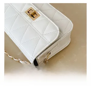 Close-up of quilted white leather bag with gold metal turn-lock and chain strap detail