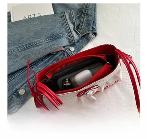 Top view of white ruffled shoulder bag with red trim showing inner storage for essentials