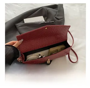 Dettaglio della borsa in pelle intrecciata che mostra l'interno con telefono e portafoglio