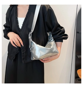 Silver metallic shoulder bag with wide strap and side zipper detail on a model