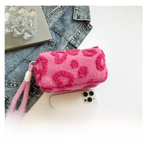 Vista detallada del bolso de peluche rosa con textura de corazón y asa de cuerda gruesa